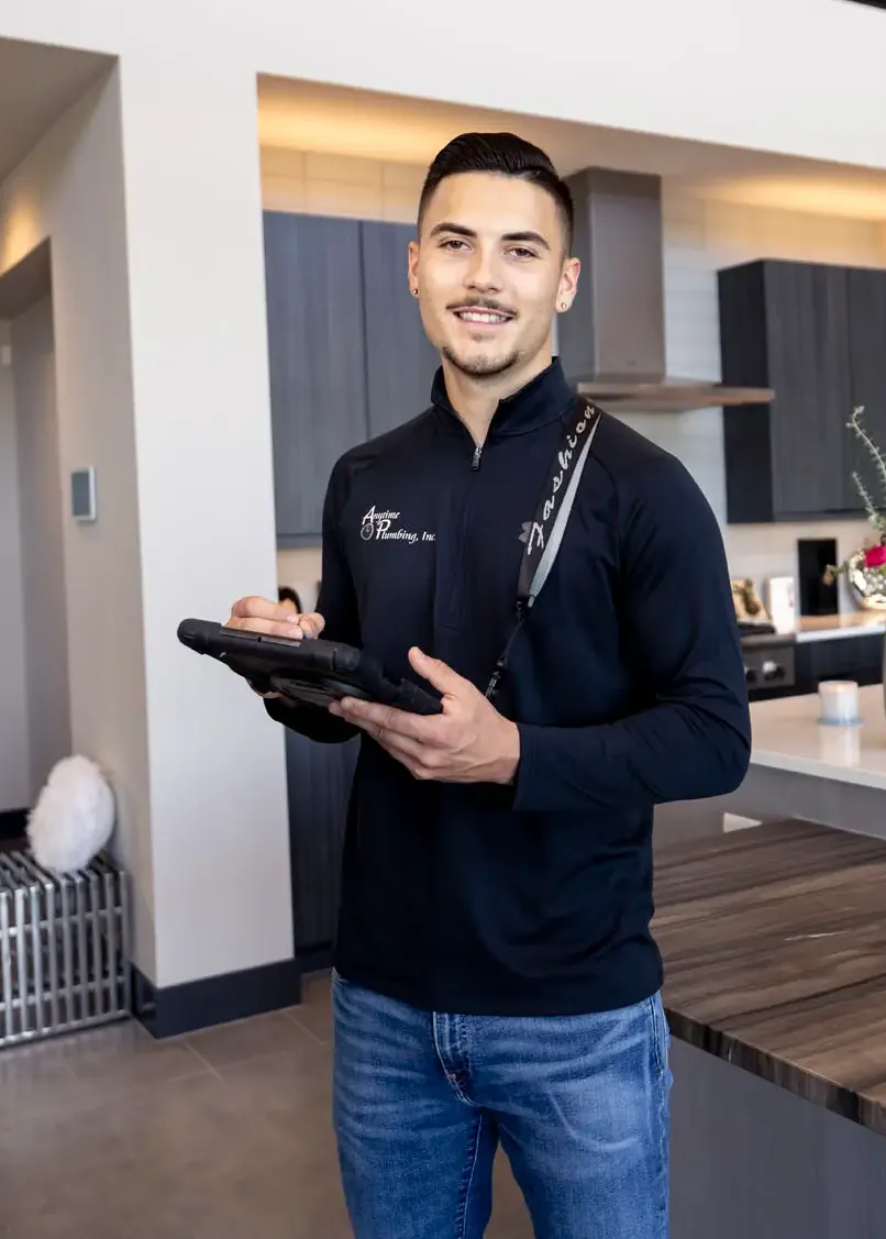 An Anytime technician holding a tablet in a modern open kitchen