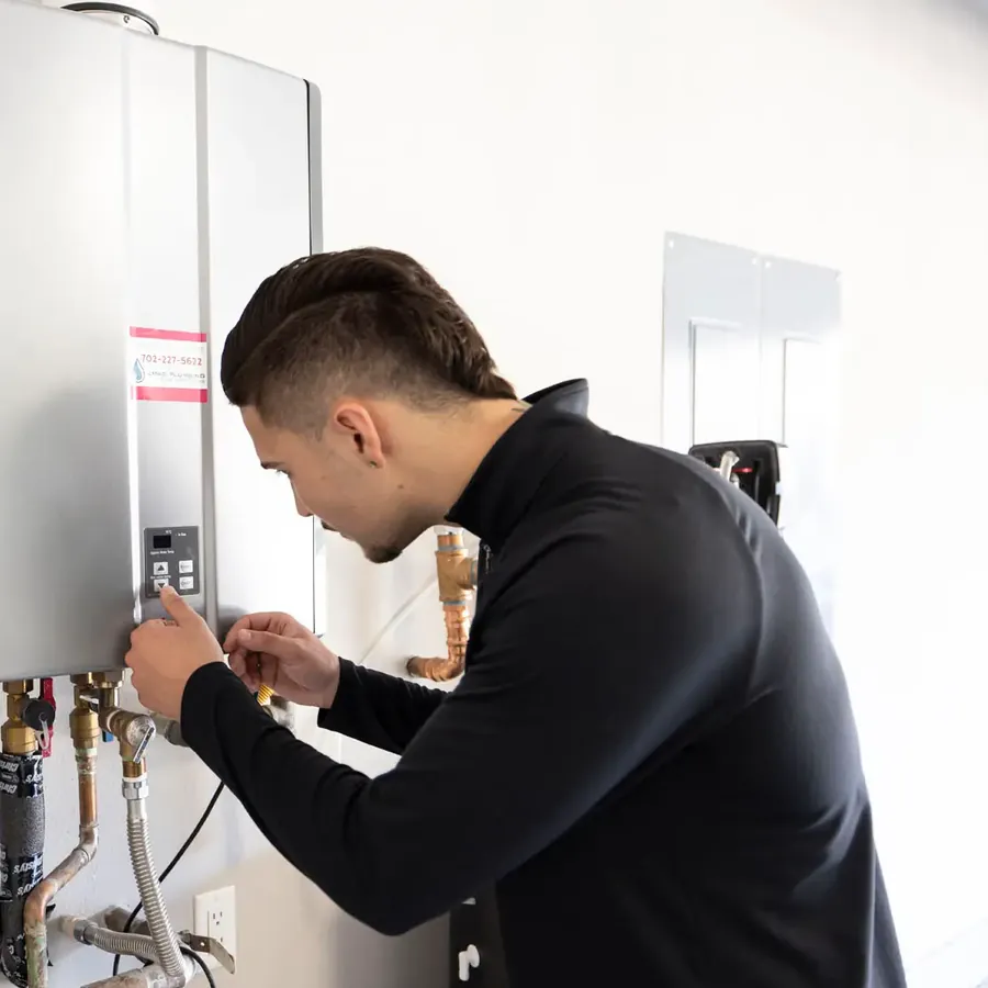 An Anytime technician at two wall-mounted tankless water heaters